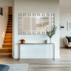 Grand miroir décoratif mural avec cadre géométrique argenté.