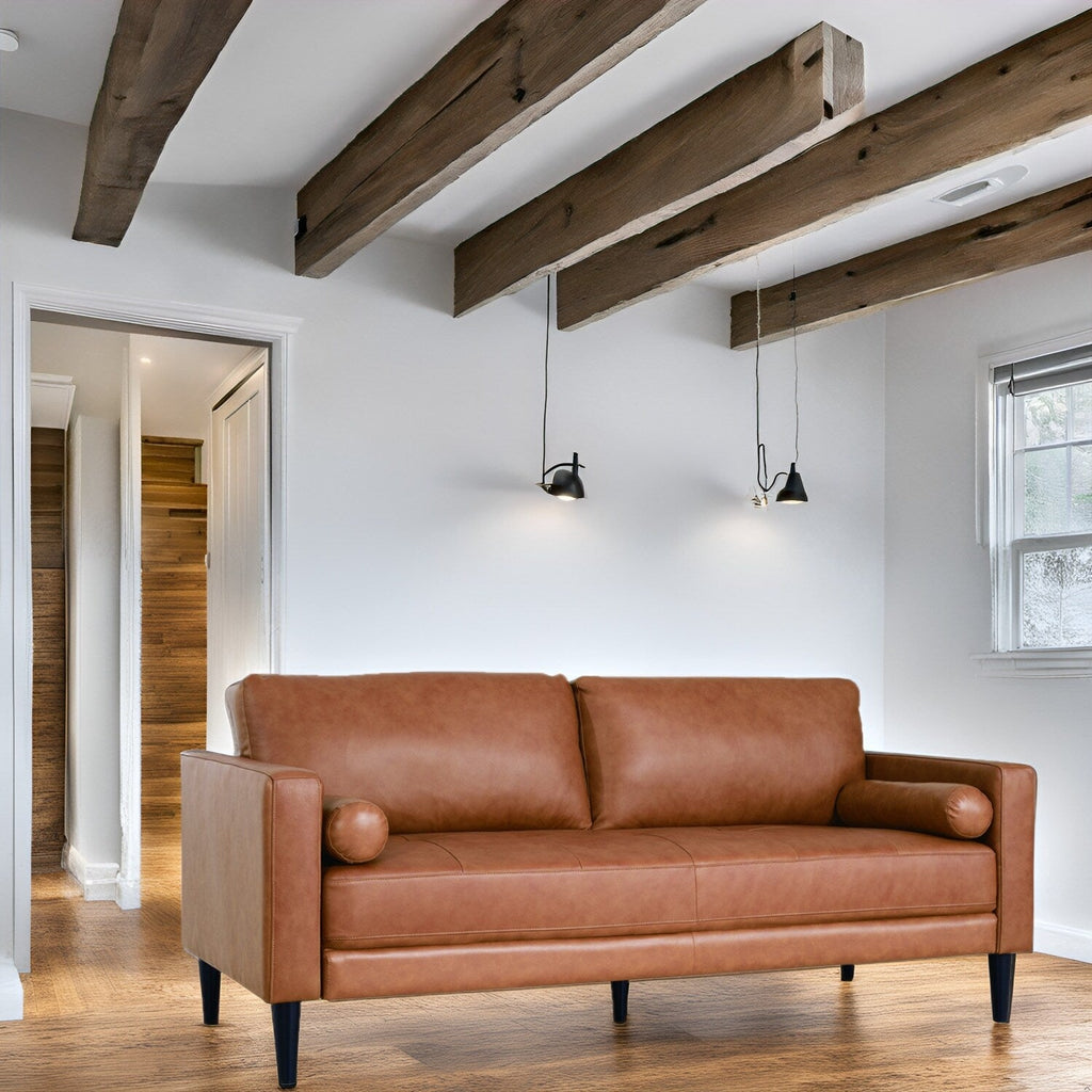 Canapé moderne en cuir véritable avec pieds en bois et coussin supplémentaire.